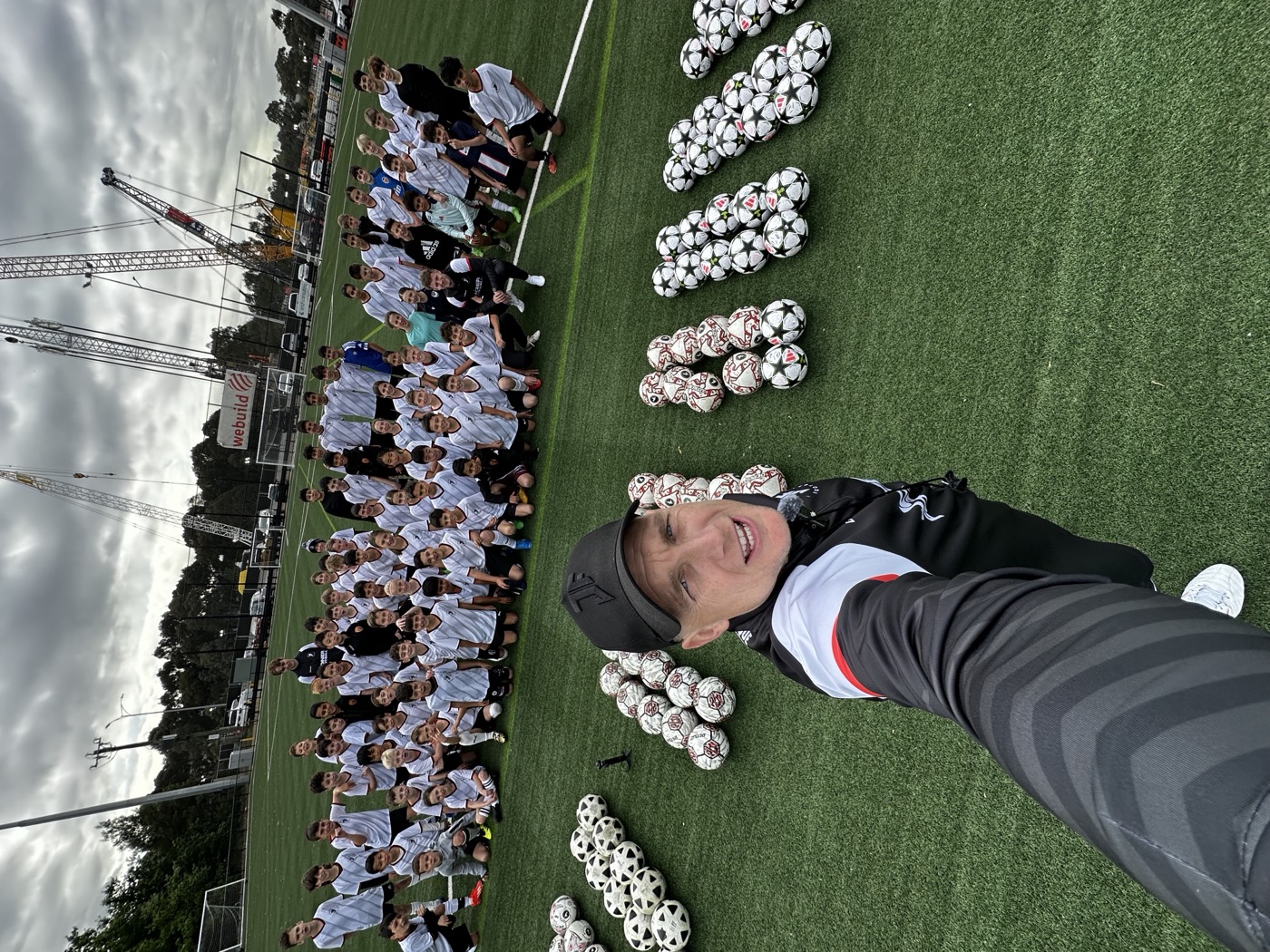 Lee with around one hundred camp players, footballs spelling JONER