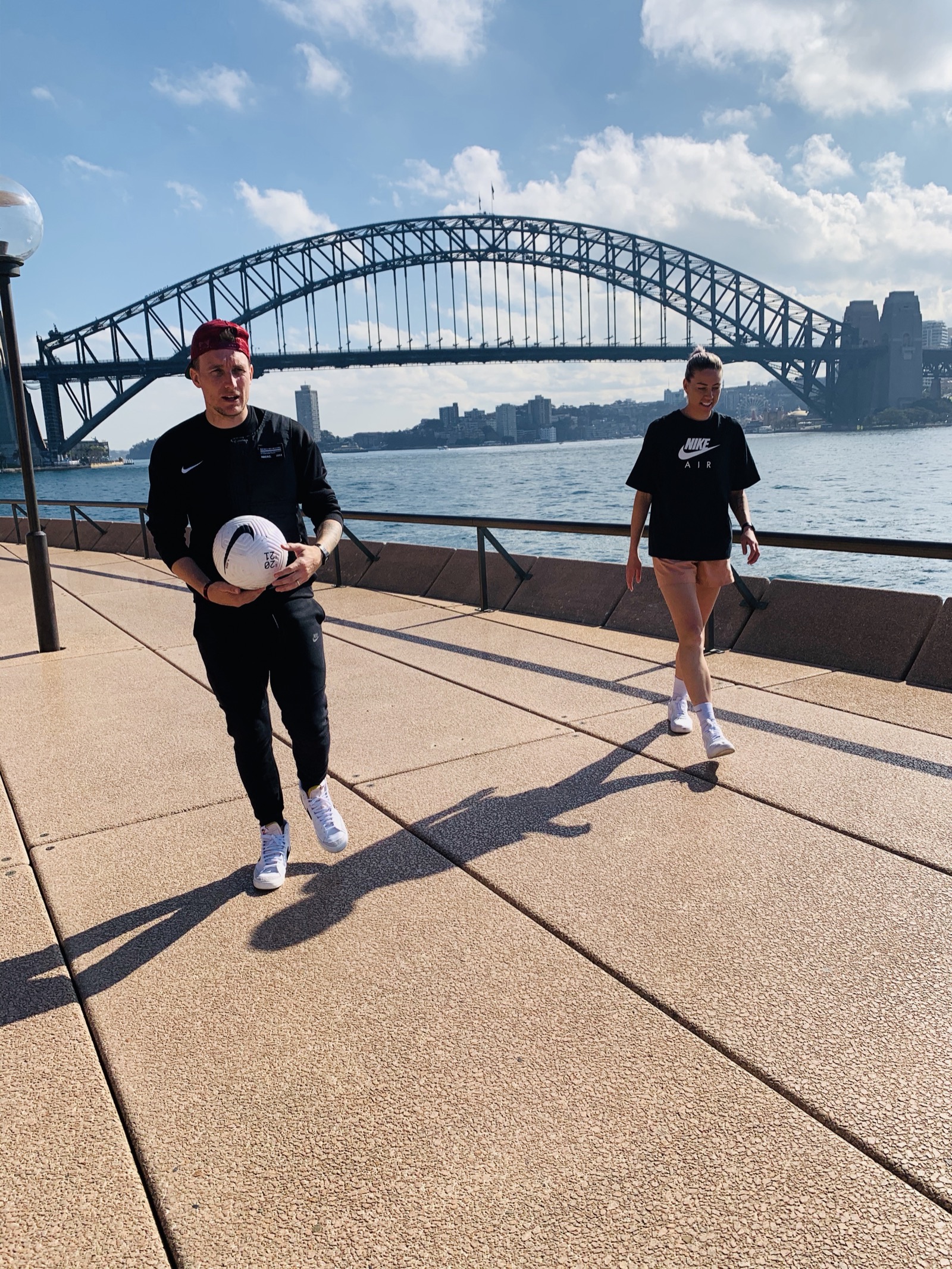 Lee walking with a football at Sydney Harbour Bridge