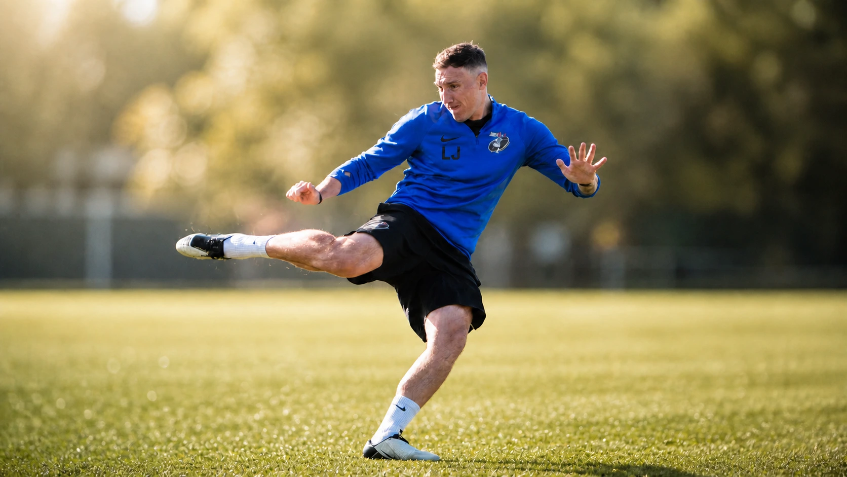 Lee Jones striking a football on grass in warm light